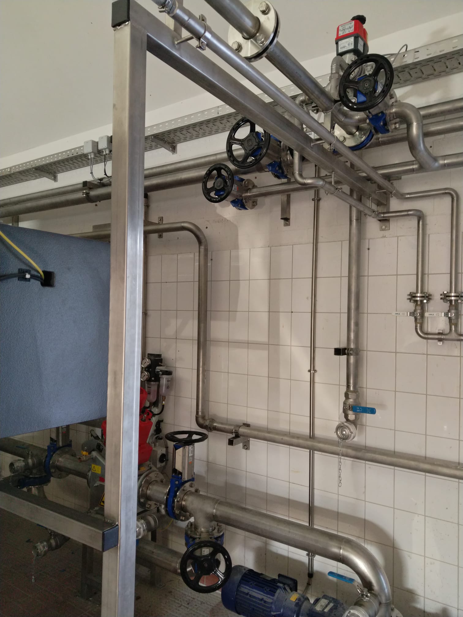 Edelstahl-Rohrleitungen, Armaturen und Pumpen in einer Kläranlage