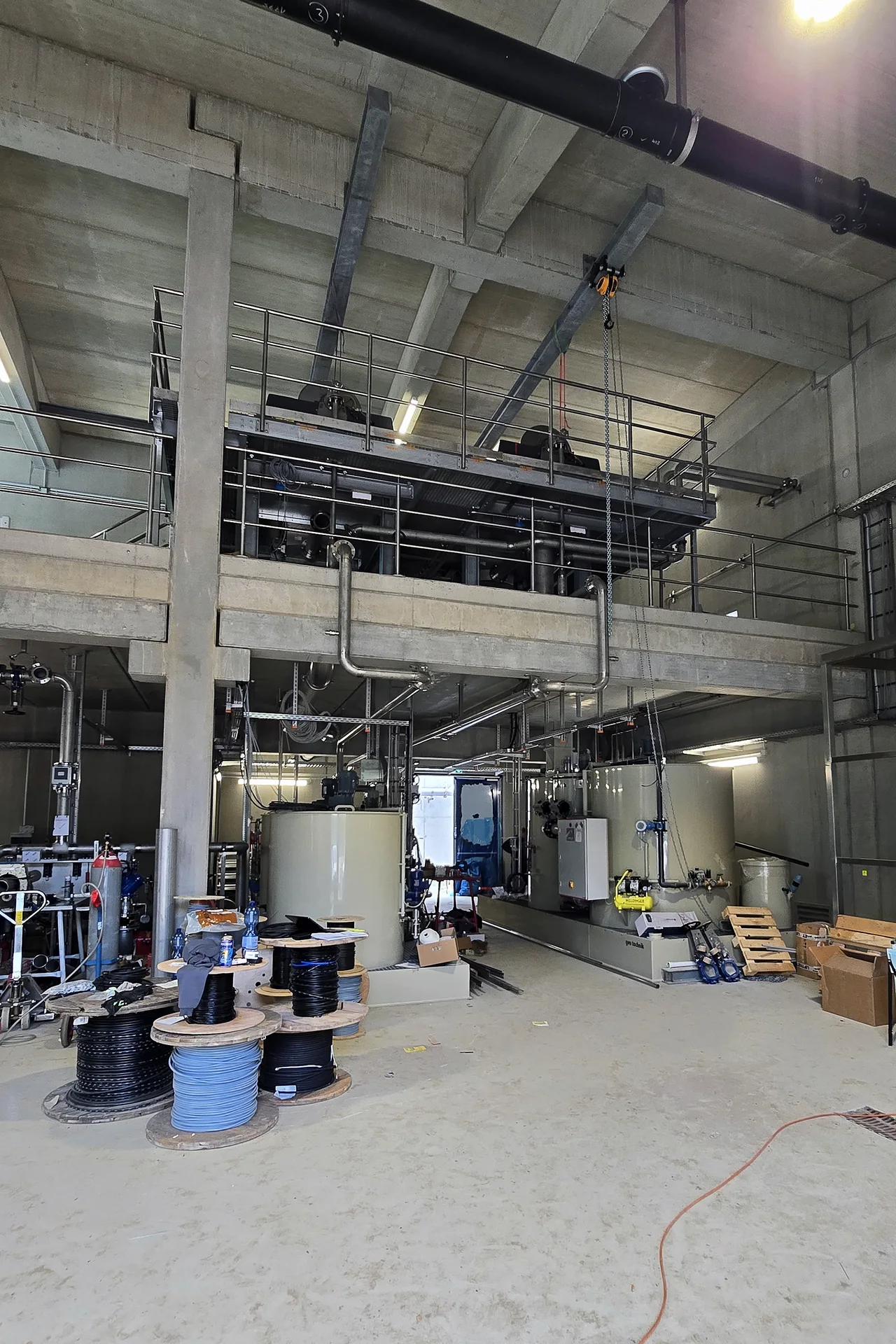 Fortgeschrittener Hallenausbau mit Maschinen, Behältern und Rohrleitungen im Projekt Schleswig
